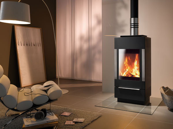 stufe design esclusivo marchio Skantherm, stufa stream con grande sportello vetrato piatto, installata in ambiente raffinato e moderno con sedia design in pelle, piastra di protezione in vetro speciale davanti alla stufa caminetto